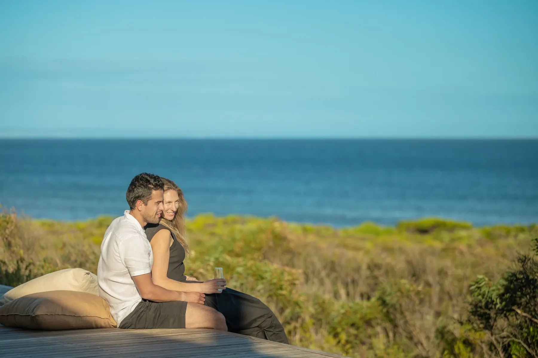 A couple on the deck of the retreat looking out to sea