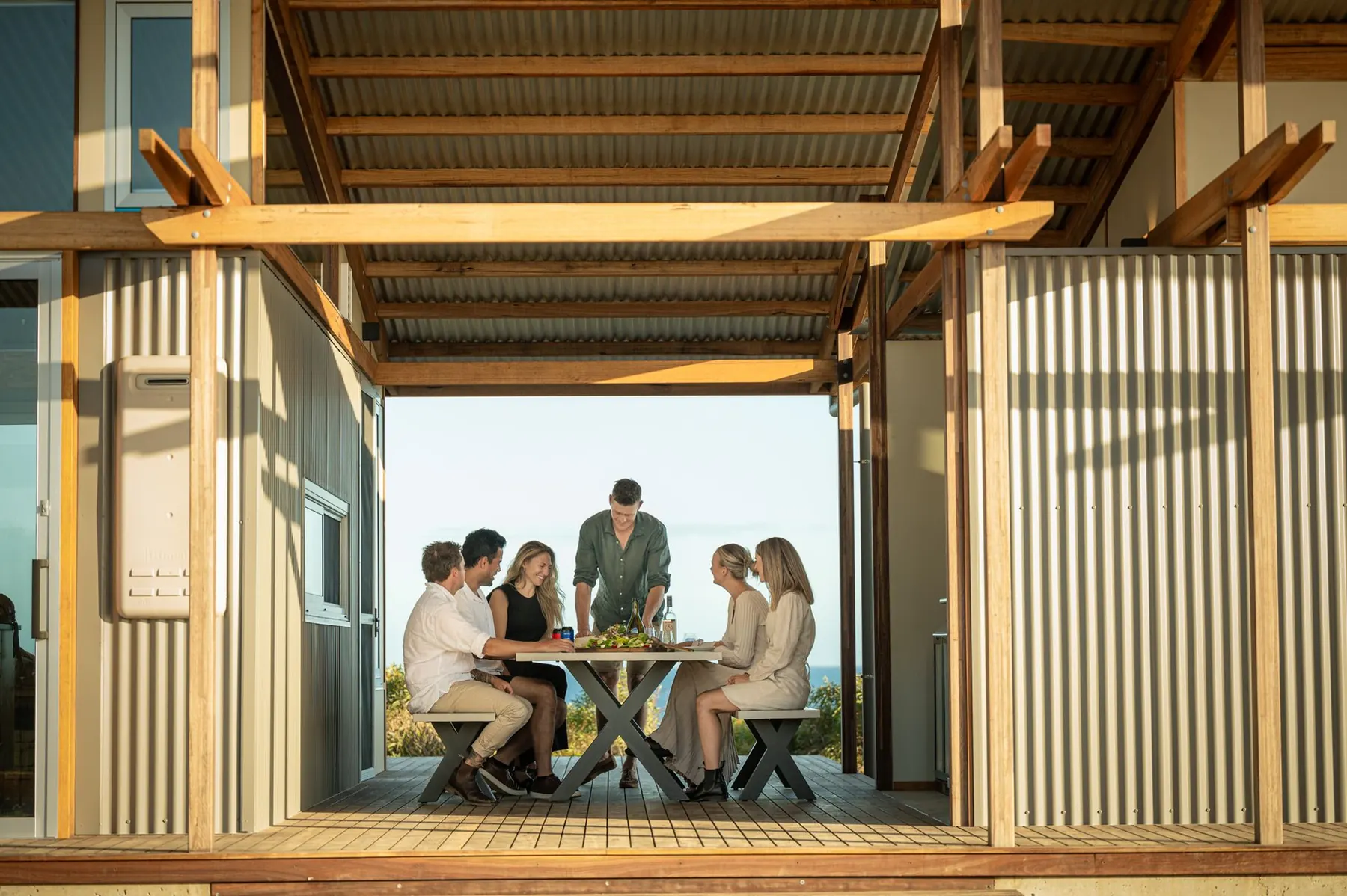 Long shared table on the deck framed by timber posts