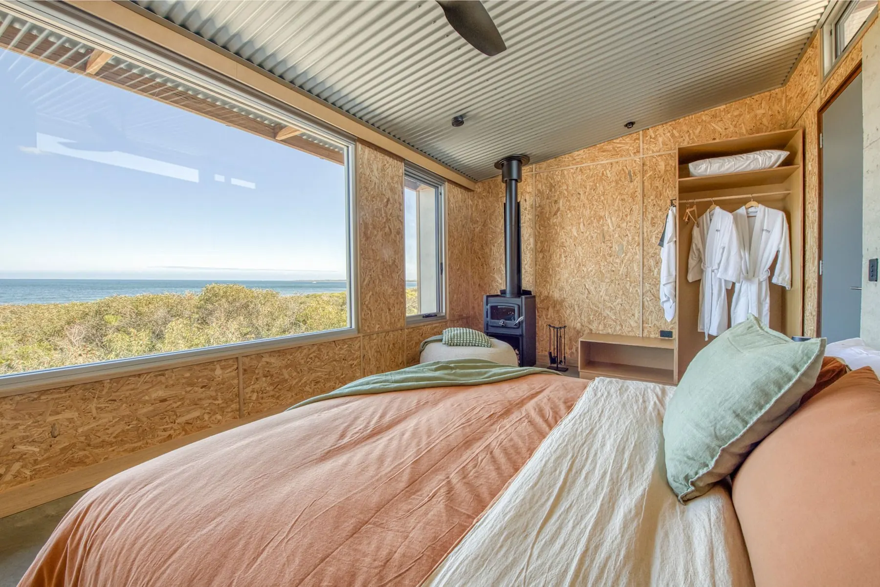 Second bedroom in plywood and concrete with a fireplace